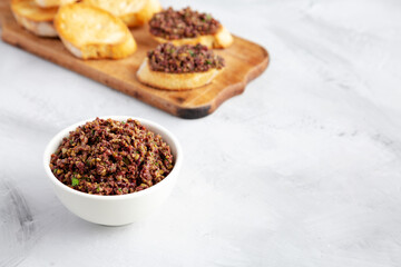 Homemade Mixed Olive Tapenade in a Bowl, side view. Space for text.