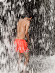 Man standing under a waterfall