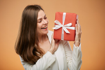 Happy woman in white suit holding red gift box. Isolated female portrait.