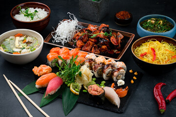 Asian food table with various kind of chinese food, noodles, sour soup, rice, sushi