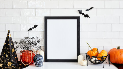 Spooky Halloween home interior with black picture frame, Halloween decorations, pumpkins. Happy...