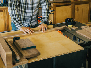 A carpenter making cuts on his tablesaw