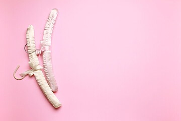 Top view flat lay different empty silk clothes hangers at pink background with copy space for text. Sale store design, shopping concept.  