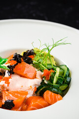 Delicate bowl of Norwegian salmon with wakame seaweed salad and diced ripe guacamole.