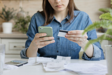 woman pays bills and utilities, counts the amount of expenses and income on a calculator. Financial...