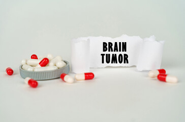 On a gray background, medical capsules and a paper plate with the inscription - Brain tumor