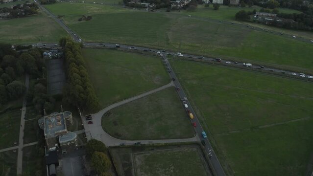 Aerial track of blackheath with busy junction of cars and traffic. 