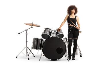 Obraz na płótnie Canvas Female drummer standing next to a drum kit