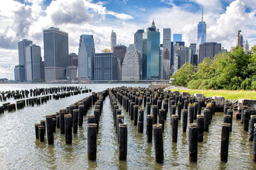 New York City Skyline showing Midtown and Lower Manhattan from the Brooklyn Bridge Park Pier 1 salt marsh. Iconic New York and famous tourist destination at the waterfront - obrazy, fototapety, plakaty