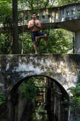 hispanic and latin man, meditating in the middle of a forest, receiving sun rays, brown skin, mexico