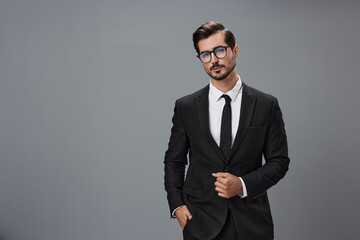 Man businessman in business suit and eyeglasses with brunette beard on gray background. The concept of good business and expensive clothes a copy space