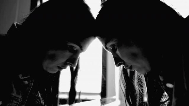 Woman suffering from depression in dramatic black and white monochromatic. Person looking at bathroom mirror own reflection