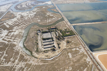 Aerial drone top view of natural sea salt ponds. Farm field outdoor. Material in traditional industry. Salt for industrial use loading in truck by labours.