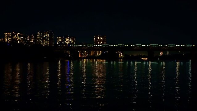 A suburban train crossing the railroad bridge at night.