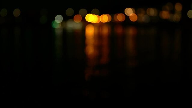 Blurred lights and reflections on the river at night.