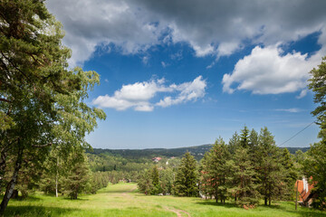Panorama of a Ski slope in summer, in Divcibare, in Serbia, with forests, a slope going down and trekking paths, used in summer for hiking.  Divcibare is one of the ski tourism destinations of Serbia