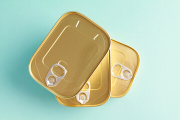Unopened sealed aluminum tin cans for safe with canned fish on 
 blue background. Long term storage of food. Steel sealed food storage. Container. Canned food. Top view. Flat lay