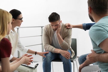 Obraz premium Psychotherapist working with group of drug addicted people at therapy session indoors