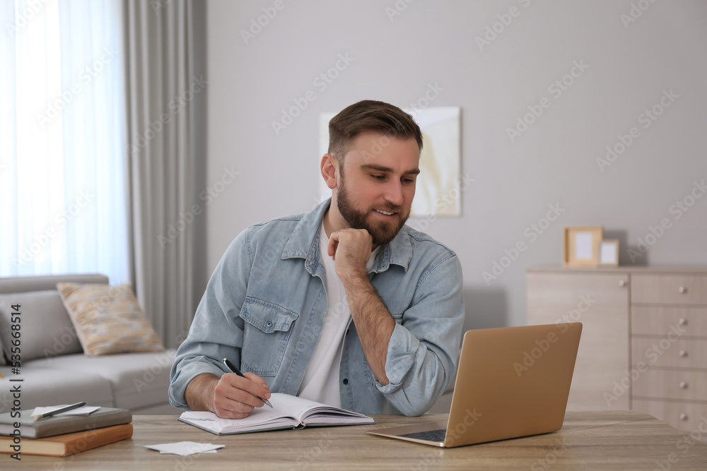 Sticker Young man taking notes during online webinar at table indoors