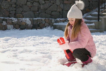 Cute little girl playing with snowball maker outdoors - obrazy, fototapety, plakaty