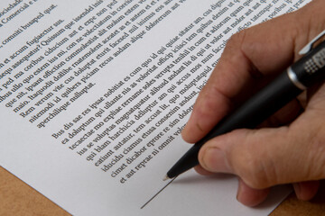 printed document signature showing a hand and ballpoint pen.