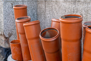 Stack of brown pvc pipes. Close up of orange plastic pipes on construction. Industrial background 
