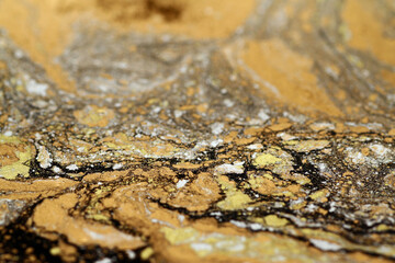 Macro shot of golden, bronze and silver particles