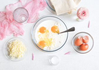 Step 2. Mixing eggs with cottage cheese and milk on a marble table.