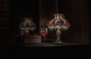 A glass of red wine in the dim light of Vintage lamp with reflection from mirror. Light and Shadow, Dark tone, Copy space, Selective focus.