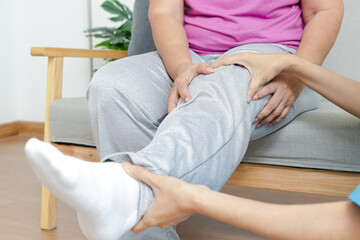 Asian female doctor doing physical therapy for elderly people with leg pain. Concept of physical...