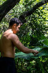 young man, doing yoga or reiki, in the forest very green vegetation, in mexico, guadalajara, bosque colomos, hispanic,