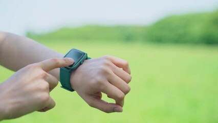 Woman using a smart watch outdoors. - Powered by Adobe