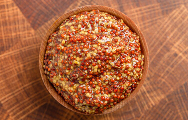 A Bowl of Whole Grain Mustard on a Wooden Butcher Block