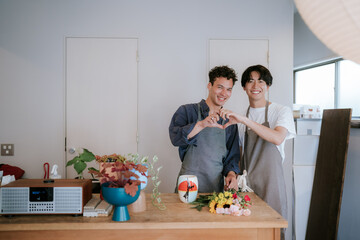 手でハート型を作るゲイの男性カップル