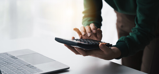 accountanth using a calculator for calculating financial expense at office to make a financial report or company's profit monthly,  finance people concept.