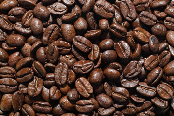 close-up view of roasted coffee beans with rich texture and glossy surfaces. Perfect for backgrounds, cafe branding, coffee advertisements, or food and beverage-related design projects. The dark