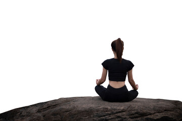 The back of a woman wearing sportswear doing a yoga pose on the rocks.