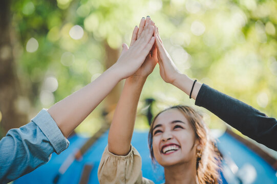 Group of women giving five to each other on camping