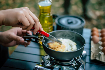 Portrait of Asian traveler man glasses frying a tasty fried egg