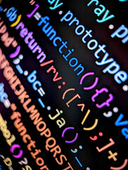 Closeup of lines of computer code displayed on a digital screen with colorful letters and numbers...