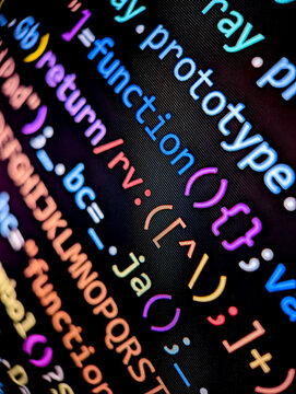 Closeup of lines of computer code displayed on a digital screen with colorful letters and numbers in dark mode on black background