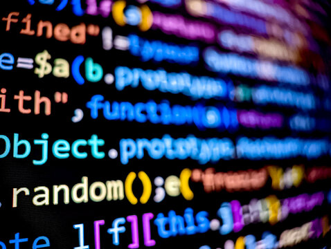 Pixelated lines of computer code displayed on a digital screen with blurred focus background