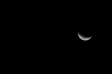 Luna en fase creciente en la inmensidad del cielo nocturno con una pequeña estrella visible © Gonzalo