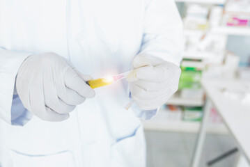 A doctor or scientist in a laboratory holding a syringe containing a liquid vaccine for a child or elderly person. Concept: disease, medical treatment, science.