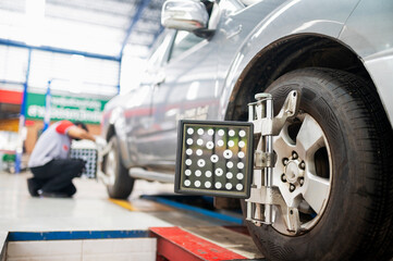 Professional mechanic near wheel center, wheel alignment, mounted on each tire for driving center....