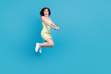 Fototapeta na wymiar Full length photo of funny sweet girl dressed green clothes jumping high riding horse empty space isolated blue color background