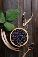 Fototapeta na wymiar Black kidney bean seed in bowl on wooden background, Table top view