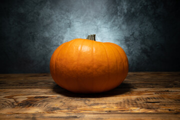 Orange pumpkin with stem cut off, autumn or fall still life.