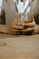 close up bartender holding a glass of whiskey