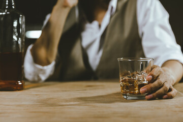 close up bartender holding a glass of whiskey